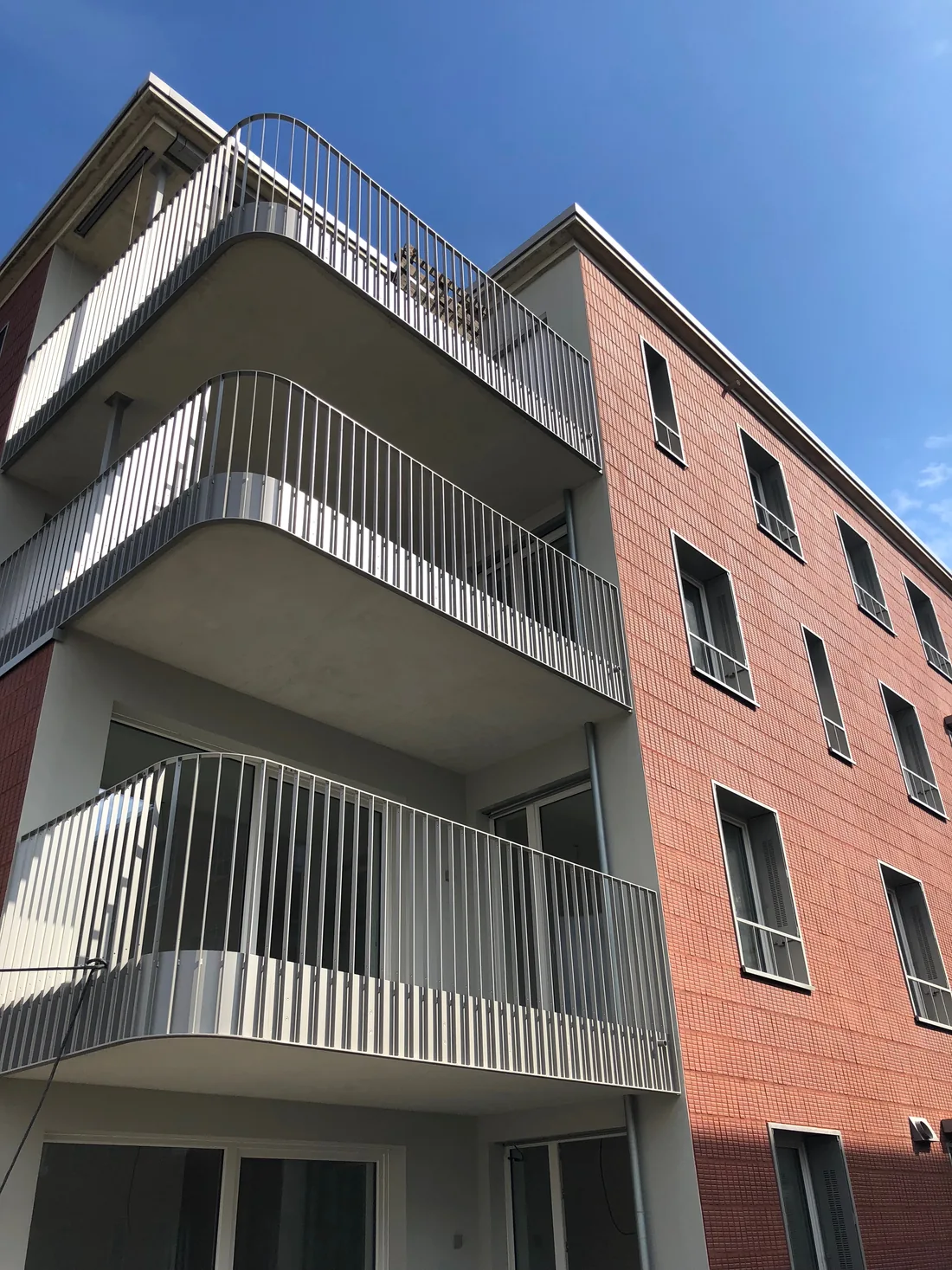Balkonanlage aus Stahl mit Füllstäben und Handlauf an einer Fassade